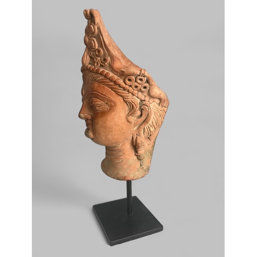 134 - A Gandharan style clay bust of Bodhisattva.Mounted on metal stand.Height - 24.5cm