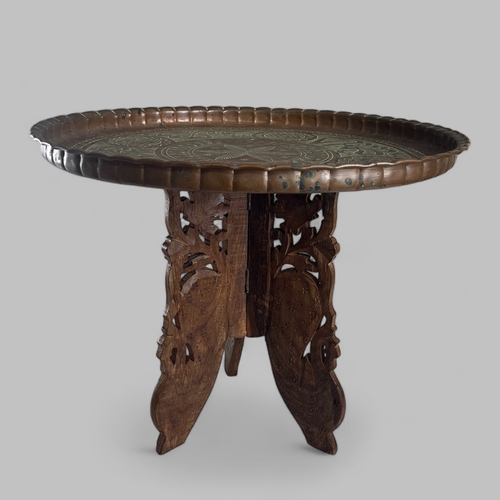 38 - A vintage Moroccan Benares table. Carved teak legs with brass top.