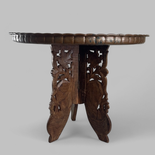 38 - A vintage Moroccan Benares table. Carved teak legs with brass top.