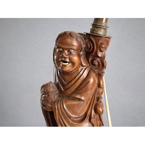 138 - A Chinese carved rootwood Luohan figural lamp.Holding captive bat.Height - 42cm