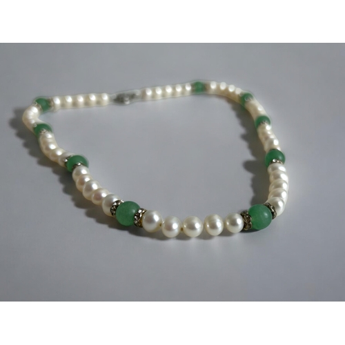 214 - A Chinese jade bangle, together with a Jade, freshwater pearl necklace & earring set. Both in gi... 