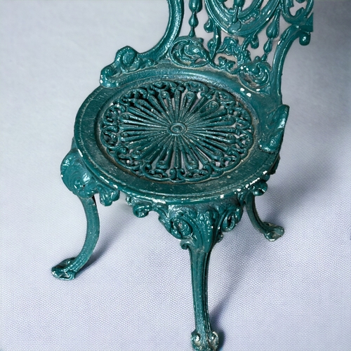 610 - A Coalbrookdale style cast iron garden spoonback chair. Painted green finish.