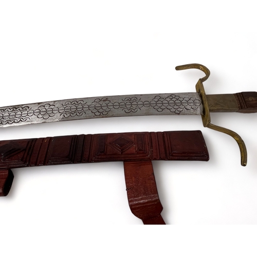 629 - A Taureg / Berber carved sword & Scabbard.
North Africa, 20th century.
Length - 110cm