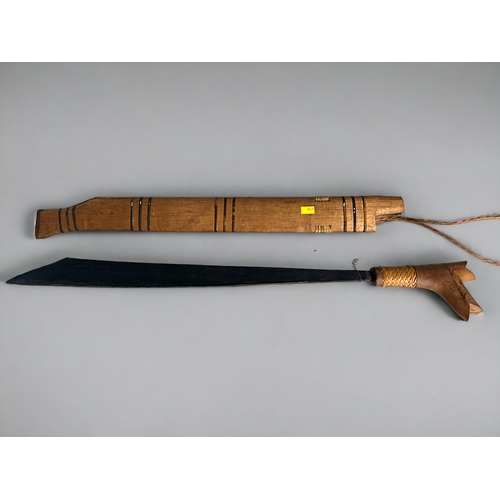 632 - An ornamental Iban parang with a 20-inch blade and carved wooden handle. The carved wooden sheath wi... 