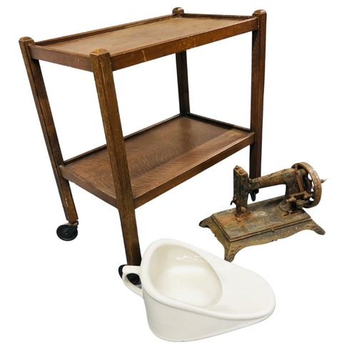 699 - An Antique Porcelain Slipper Bed Pan with an Antique well worn sewing machine and a Hostess Trolley