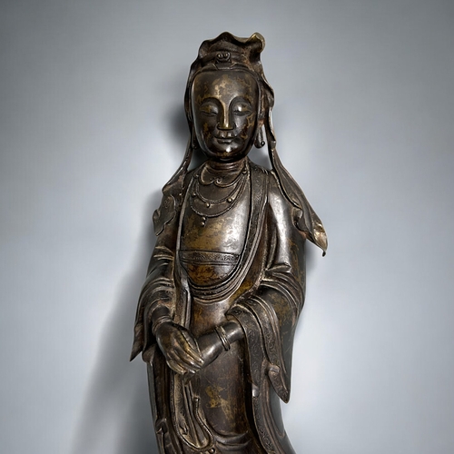 11 - A large bronze figure of Guanyin.Chinese, Qing dynasty. Standing, with crossed hands pose with long ... 