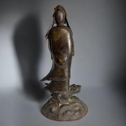 11 - A large bronze figure of Guanyin.Chinese, Qing dynasty. Standing, with crossed hands pose with long ... 