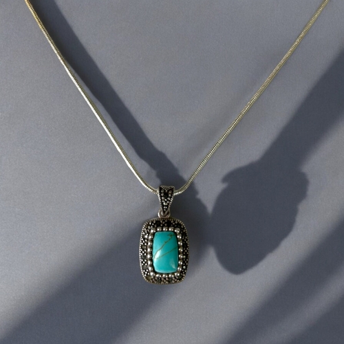 530 - A sterling silver & Turquoise pendant, together with a silver chain.