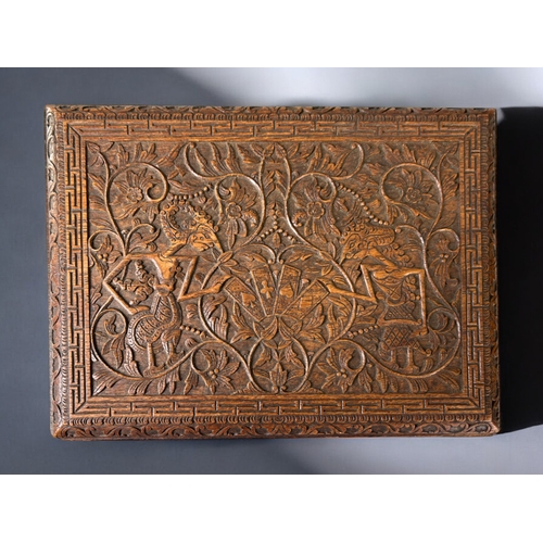 14 - Intricately carved Javanese card box.Depicting Wayang puppets and playing cards amongst stylised fol... 