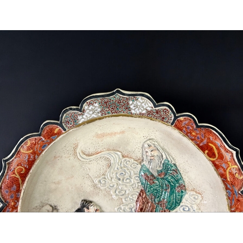 19 - A Japanese Satsuma dish.Meiji period, 19th century.Relief decorated, depicting an offering to celest... 