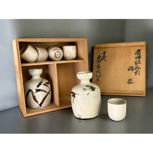 146 - A boxed Japanese pottery Sake set.Together with a boxed set of lacquer serving dishes.