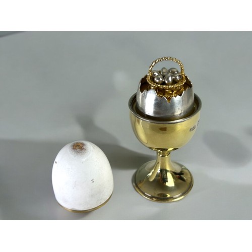 486 - A Silver gilt and enamel 'Surprise' egg.By Anthony Elson.London, 1979 hallmarks.White enamel egg lif... 