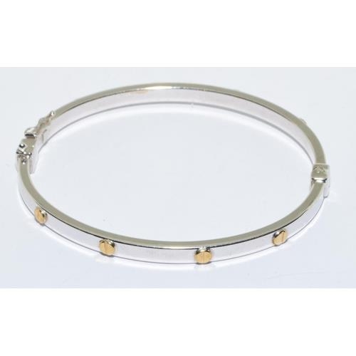 563 - 9ct white gold solid bangle in a cartier love bangle design hinged spring clip closing 7.0g