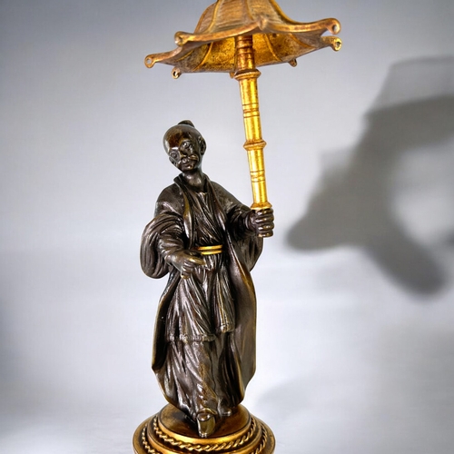 436 - A Charles X Gilt and Patinated bronze Chinoiserie candlestick.French, 1st quarter 19th century.Heigh... 