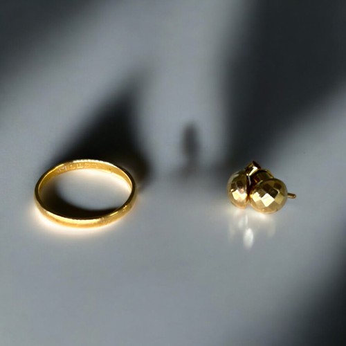 606 - A 22ct gold wedding band, together with a  9ct gold stud earrings and a  yellow metal and jade penda... 