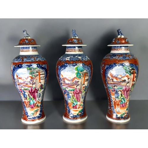 32 - A garniture of three Chinese export porcelain Mandarin vases.Qing dynasty, 18th century.Baluster for... 