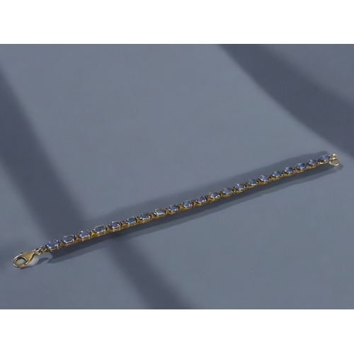 497 - A silver gilt & Tanzanite tennis bracelet.Set with 21 Tanzanite.Length - 8