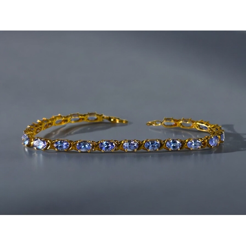 497 - A silver gilt & Tanzanite tennis bracelet.Set with 21 Tanzanite.Length - 8