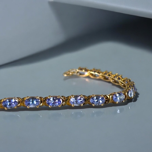 497 - A silver gilt & Tanzanite tennis bracelet.Set with 21 Tanzanite.Length - 8