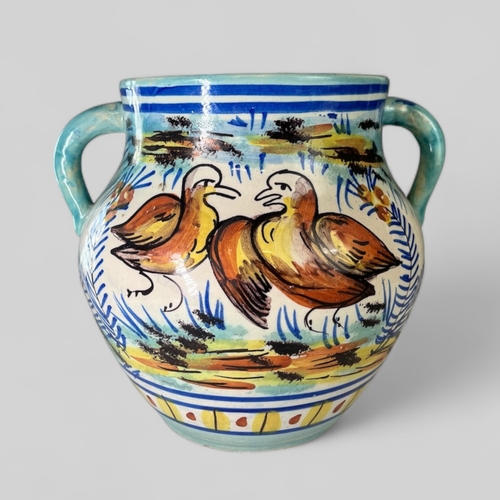 116 - A 19th century Spanish Faience twin handle pot. Polychrome painted pairs of birds in naturalistic se... 