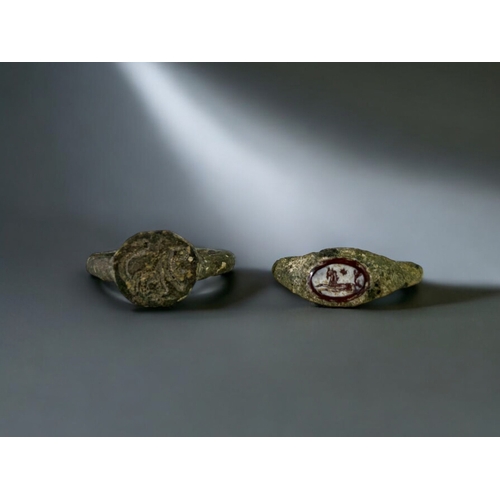 561 - Two Roman Bronze Intaglio rings.2nd-3rd century AD.The first carved agate depicting a leaping horse.... 