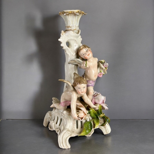 138 - A late 19th century German Plaue porcelain comport / candlestick.Depicting a pair of cherubs amongst... 