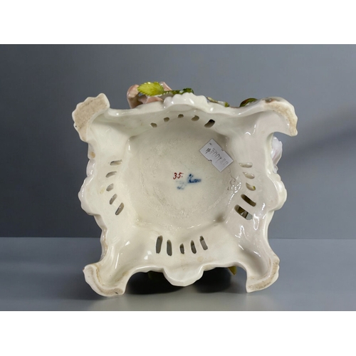 138 - A late 19th century German Plaue porcelain comport / candlestick.Depicting a pair of cherubs amongst... 