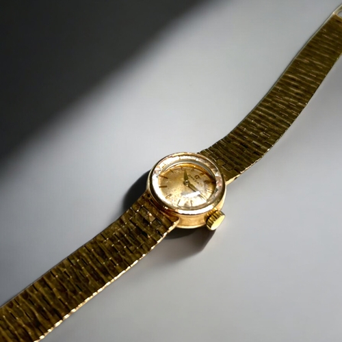 506 - A vintage ladies 9ct Gold Omega cocktail wristwatch.With 9ct gold bark effect strap.Both hallmarked.... 