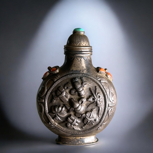 55 - Tibetan silver snuff bottle.C1800-50. Mounted with coral & turquoise. Roundel to each side Relie... 