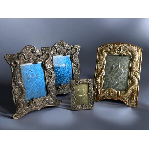 88 - A collection of four Japanese antimony photo frames.Including a pair embossed with Dragons contestin... 