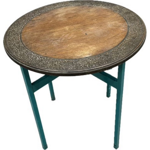 181 - Carved circular wooden table on folding metal detachable legs.