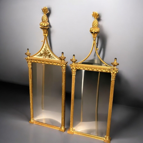 140 - A pair of Giltwood Eglomise Pier mirrors.In the Regency style.Each with Pineapple finials, hung with... 