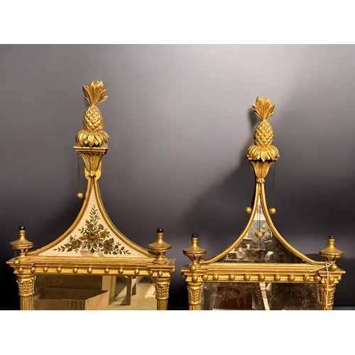 140 - A pair of Giltwood Eglomise Pier mirrors.In the Regency style.Each with Pineapple finials, hung with... 