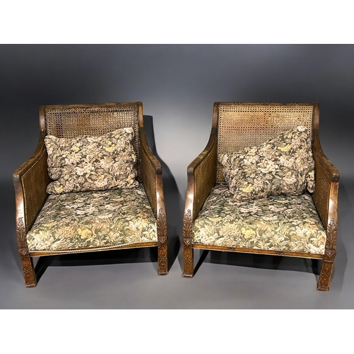 148 - A pair of Cane & carved Mahogany Bergère armchairs.With floral design upholstery.