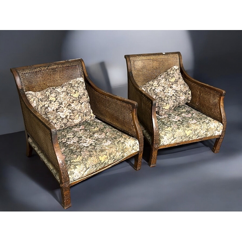 148 - A pair of Cane & carved Mahogany Bergère armchairs.With floral design upholstery.