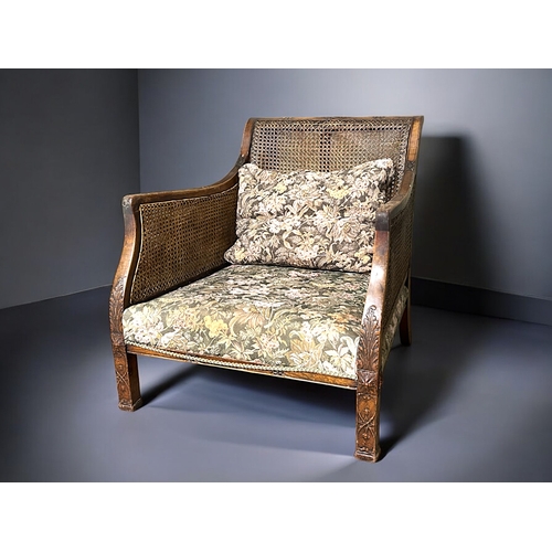 148 - A pair of Cane & carved Mahogany Bergère armchairs.With floral design upholstery.