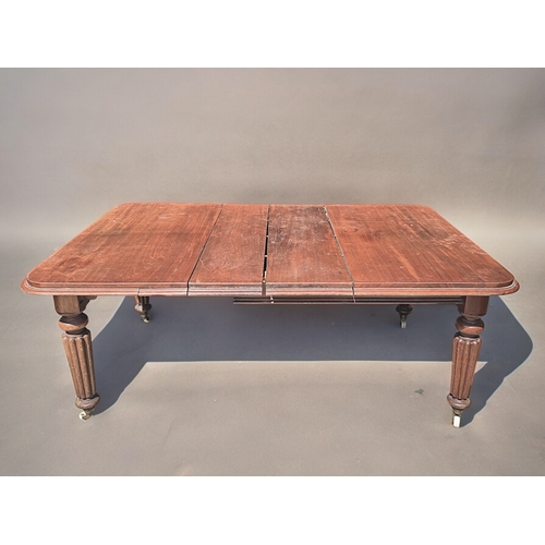 157 - A 19th century Mahogany wind-out extending table.Turned & fluted legs, raised on casters. Two dr... 