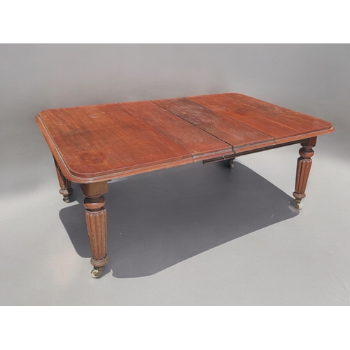 157 - A 19th century Mahogany wind-out extending table.Turned & fluted legs, raised on casters. Two dr... 