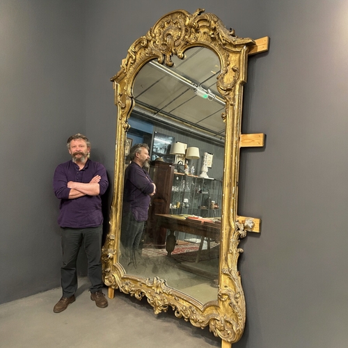 160 - A huge Louis XVI style carved gilt wood mirror.France, 19th century.Stylised scrolling designHeight ... 