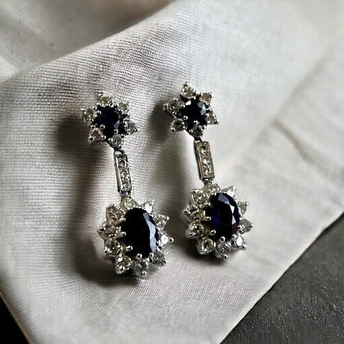 550 - A PAIR OF 18 CARAT WHITE GOLD, DIAMOND & SAPPHIRE DROP EARRINGS. Each set with an Oval & rou... 