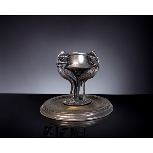 520 - A 19th CENTURY SILVER PLATE INKWELL.
Depicting three tall Cranes, each with a snake in their mouth. ... 