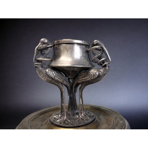 520 - A 19th CENTURY SILVER PLATE INKWELL.
Depicting three tall Cranes, each with a snake in their mouth. ... 