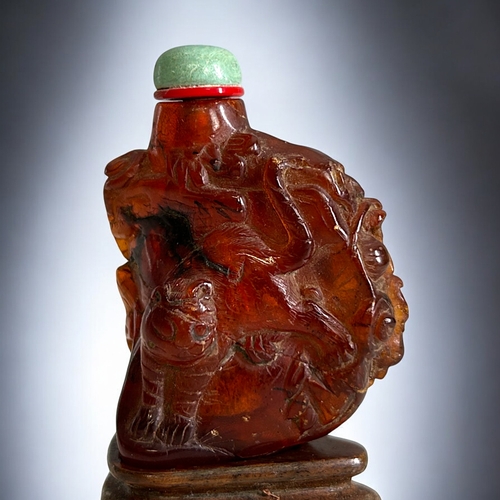 70 - Chinese carved Amber snuff bottle.Qing dynasty, 18th/19th Century.Irregular form, with intricately C... 