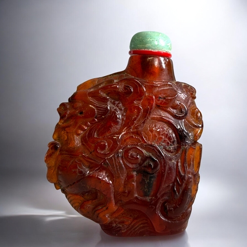 70 - Chinese carved Amber snuff bottle.Qing dynasty, 18th/19th Century.Irregular form, with intricately C... 