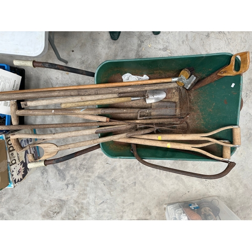 385 - A dozen of garden ustensils containing forks, spades, rakes etc. along with a wheelbarrow and a pair... 