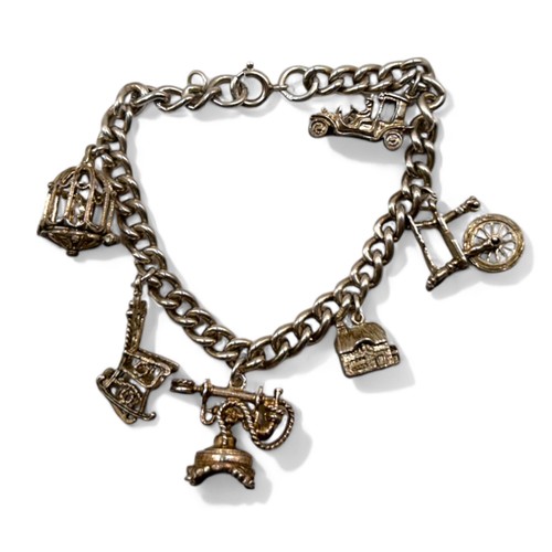 65 - A sterling silver charm bracelet, fitted with six large charms.