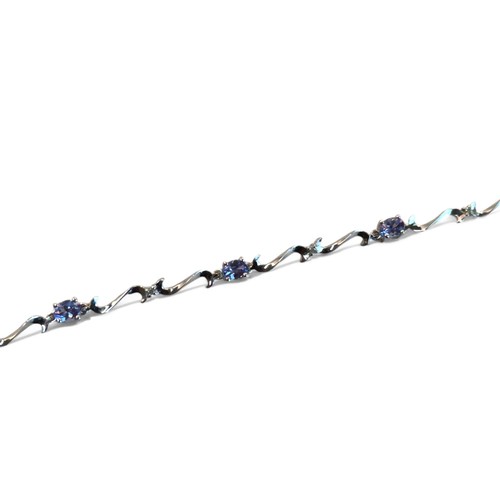 257 - A 9ct white gold, tanzanite and diamond bracelet.Set with seven beautiful oval cut Tanzanites, prong... 