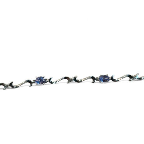 257 - A 9ct white gold, tanzanite and diamond bracelet.Set with seven beautiful oval cut Tanzanites, prong... 