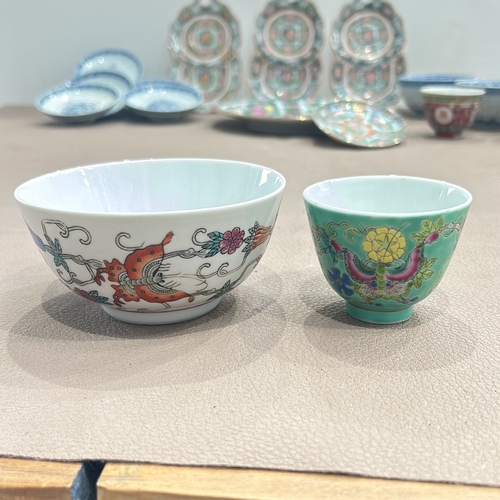 86 - Assorted Chinese porcelain dishes and bowls feature vibrant Famille Rose and blue-and-white designs.... 