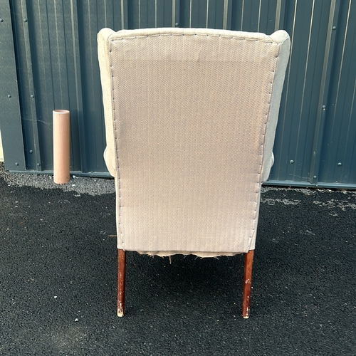 91 - Upholstered beige wingback armchair with curved wooden legs. Vintage style.